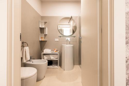 ein Badezimmer mit Toilette und Spiegel in der Unterkunft KT exclusive hotel in Cagliari
