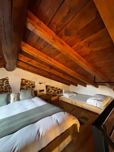 an attic room with two beds in it at El Balcón de Urbiés in Mieres