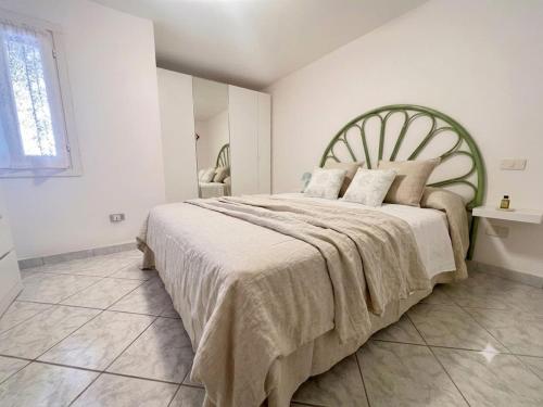 a bedroom with a large bed with a green headboard at Sardinia Re - Grecale 39 in Porto Rotondo