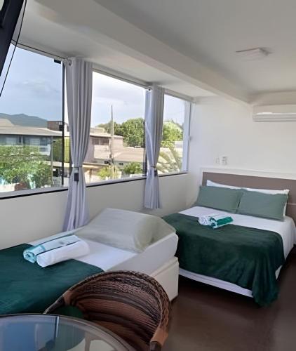 a bedroom with a bed and a large window at Pousada da Mel in Florianópolis