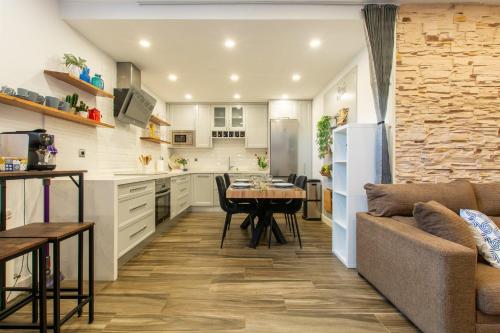 a kitchen and living room with a table and a couch at Charming Studio with Pool Retreat in Arroyomolinos