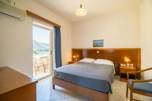 a hotel room with a bed and a large window at Hiona Holiday Hotel in Palekastron