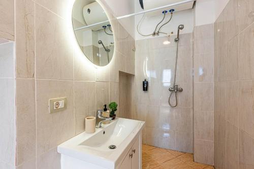 a bathroom with a sink and a mirror and a shower at Dhermi's Icon Big 1BR Ap 15 in Dhërmi