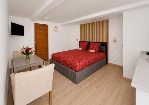 a bedroom with a red bed and a table at Les 4 AS de Jaunay, Le Cocon, Futuroscope in Jaunay-Clan