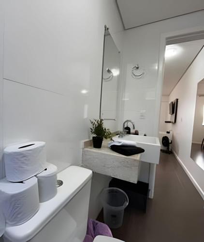 a white bathroom with a sink and a mirror at Pousada da Mel in Florianópolis