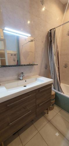 a bathroom with a sink and a mirror and a tub at Dolce bilocale con terrazzo in Nice