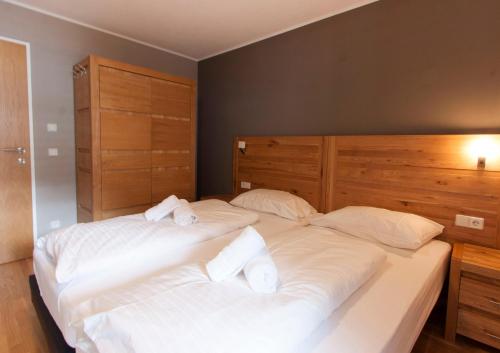 a bedroom with two beds with white sheets and towels at Appart Laijola in Gaschurn