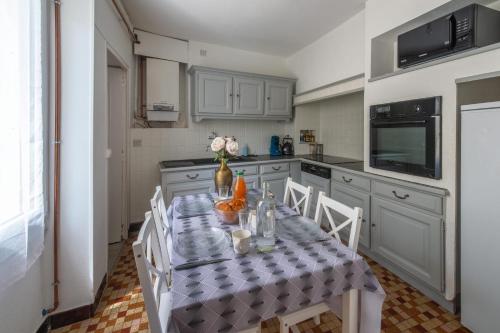 a kitchen with a table and chairs in a kitchen at Brise Lavalloise - Wifi - Centre Ville in Laval