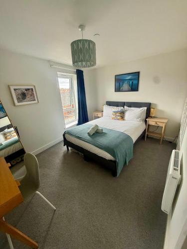 a bedroom with a large bed and a window at Number 15 Luxurious Two Bedroom Apartment - free secure parking in Exmouth