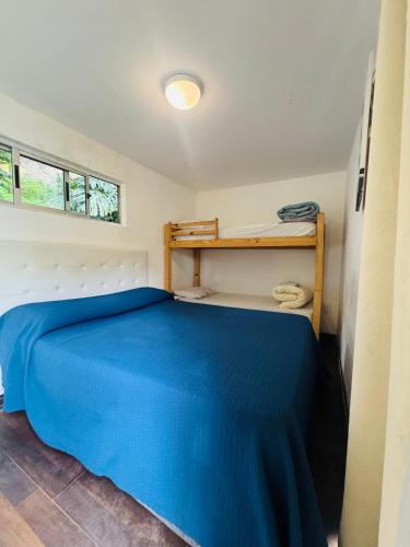 a bedroom with a blue bed in a room at Posada CASA in Punta del Este