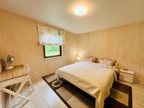 a bedroom with a large bed and a window at Kabakėlio slėnis in Kabakelis
