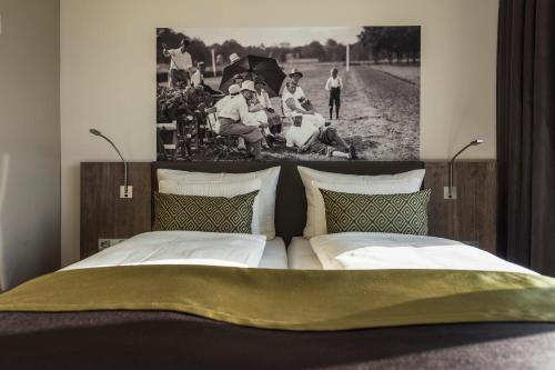 a bedroom with a bed with a picture on the wall at Hotel TheGreen in Cologne