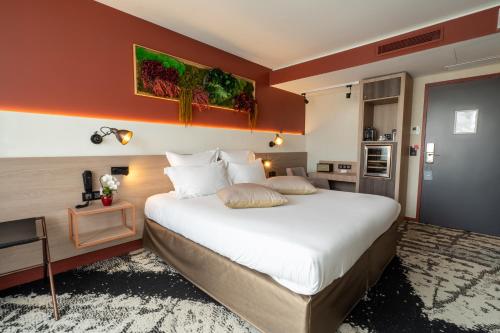 a bedroom with a large white bed and orange walls at Hôtel B55 in Paris