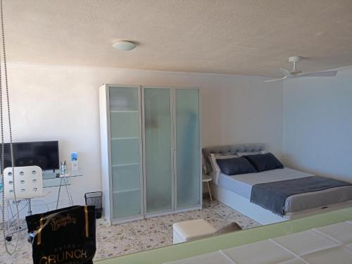 a bedroom with a bed and a tv in it at Campello Muchavista Beach in El Campello
