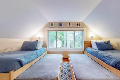 two beds in a room with a window at Gunstock Getaway in Gilford