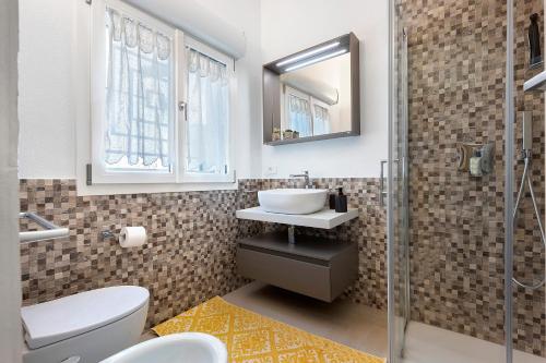 a bathroom with a sink and a toilet and a mirror at Lu Furru Apartments in Telti