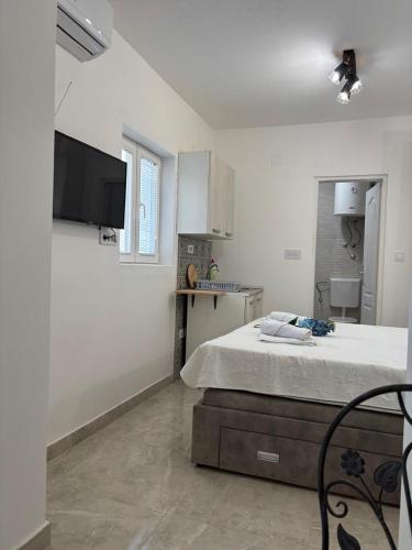 a bedroom with a bed and a tv on the wall at Fortunella Apartments in Herceg-Novi