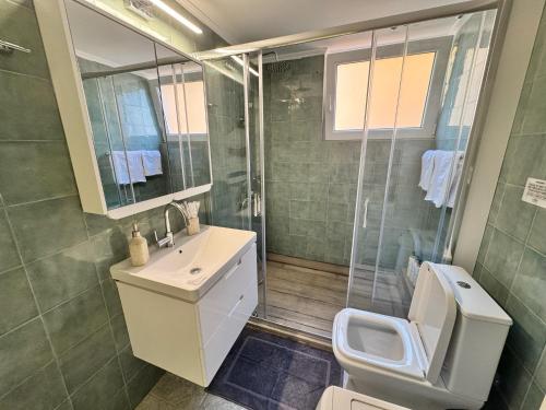 a bathroom with a toilet and a sink and a shower at Central Mytilene City-View Apartment for 7 in Mytilene
