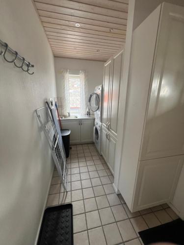 a small bathroom with a sink and a washing machine at Arctic Hostel Apartment in Qaqortoq
