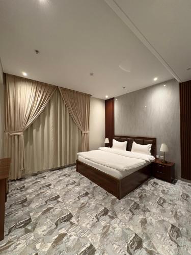 a bedroom with a large bed and a stone floor at بريفير للشقق المخدومة - Privere Serviced Apartments in Riyadh