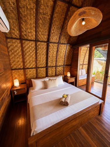 a bedroom with a large bed in a room at Kokonut Resor Amed in Amed