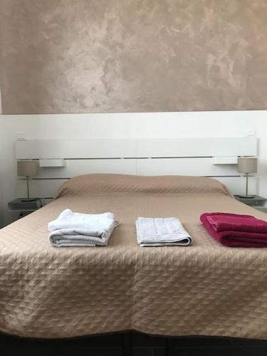 a bed with two towels on top of it at affittacamere alloggio olivo Empoli a pochi passi dalla stazione in Empoli