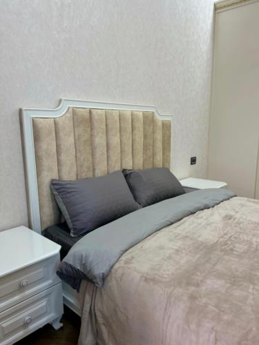a bedroom with a large bed and a white dresser at Malibo Central Apartments in Baku