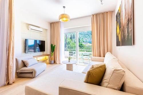 a living room with a couch and a tv at Dhermi's Icon Big 1BR Apt 6 in Dhërmi