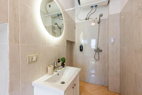 a bathroom with a sink and a shower with a mirror at Dhermi's Icon Big 1BR Apt 6 in Dhërmi