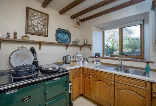 a kitchen with a stove and a sink at Mowhay Barn in Torpoint
