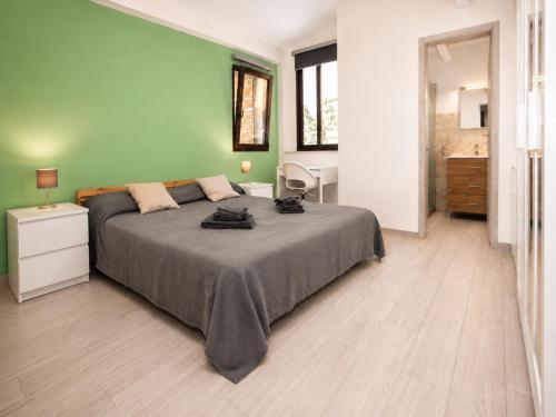 a bedroom with a large bed and a green wall at Casa della Salvia con Piscina, relax in campagna vicino al mare in Santa Croce Camerina
