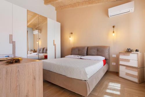 a bedroom with a bed and a dresser and a mirror at Lu Furru Apartments in Telti