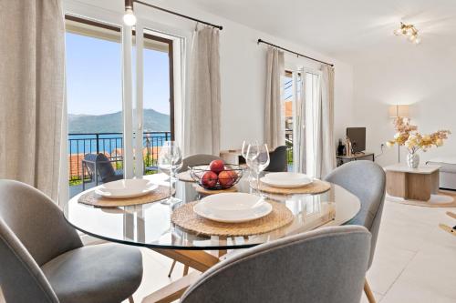 a dining room with a glass table and chairs with a view at Villa Bokeljka in Krašići