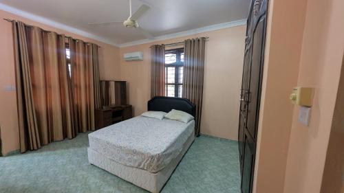 a bedroom with a bed and a window at Furaha House in Chukwani