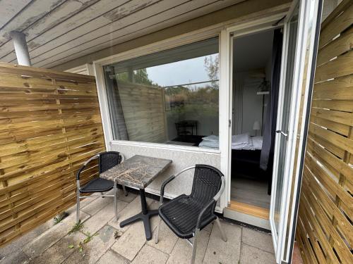 a patio with a table and chairs on a balcony at Slottets Anneks in Rønne