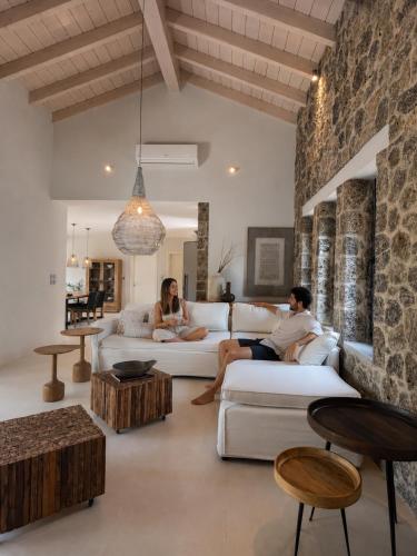 two people sitting on a couch in a living room at Villa Tartaya Boutique Villa with Private Pool in Corfu in Dassia