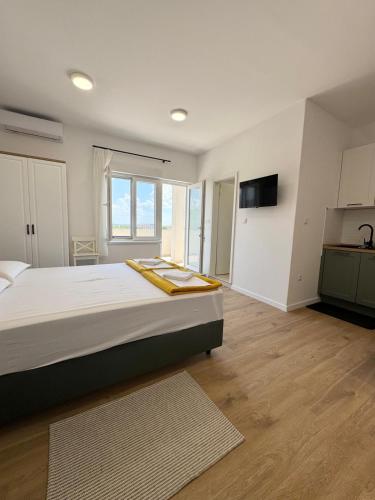 a large bedroom with a large bed and a kitchen at Studio Sanja in Vlašići