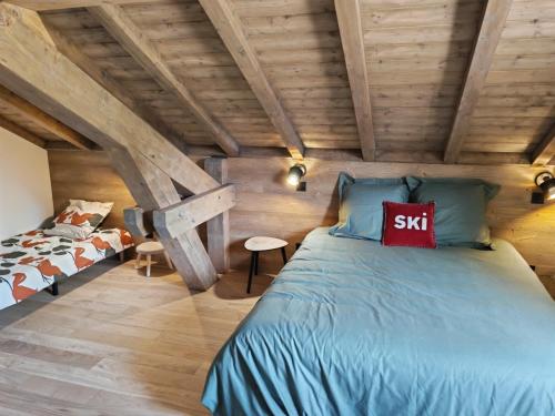 a bedroom with a bed in a attic at Le BÔ Chalet - Jacuzzi et Sauna - 3 chambres in Anould