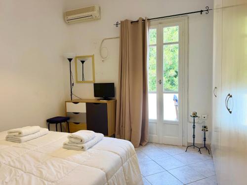 a white bedroom with a bed and a window at Anemochadi in Agios Sostis