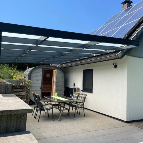 a patio with a table and chairs under a roof at All inclusive Ferienhaus JULYN , Seepark in Kirchheim