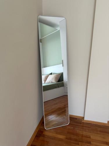 a mirror in a room with a bed at Zen Apartment in Kumanovo