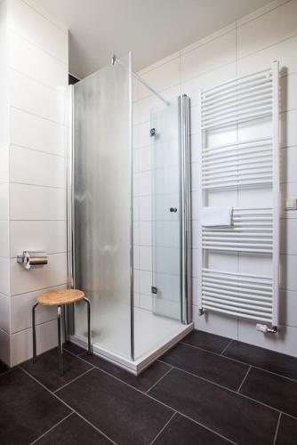 a bathroom with a shower and a wooden stool at Hotel -Winterfelder Hof in Winterfeld