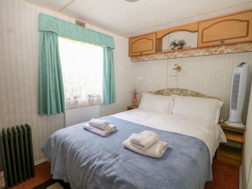 a bedroom with two towels on a bed at 10 Cater Gardens in Guildford