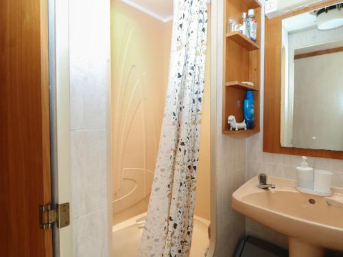 a bathroom with a shower curtain and a sink at 10 Cater Gardens in Guildford