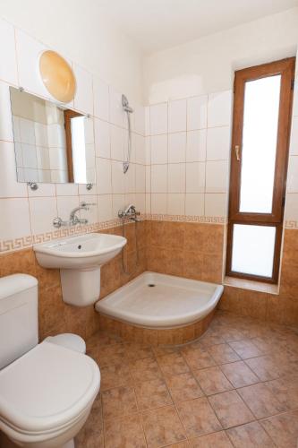 a bathroom with a toilet and a tub and a sink at Hotel M2 in Primorsko