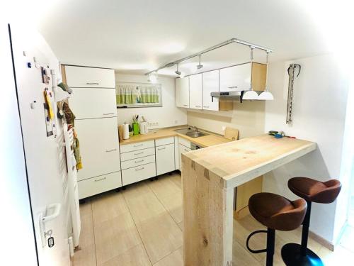 a kitchen with a wooden table and a refrigerator at Ferienwohnung Kleinwalsertal in Hirschegg