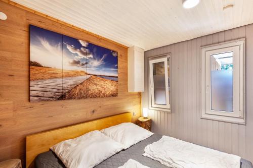 a bedroom with a bed and two windows at Ferienhaus 203 in Zadelsdorf