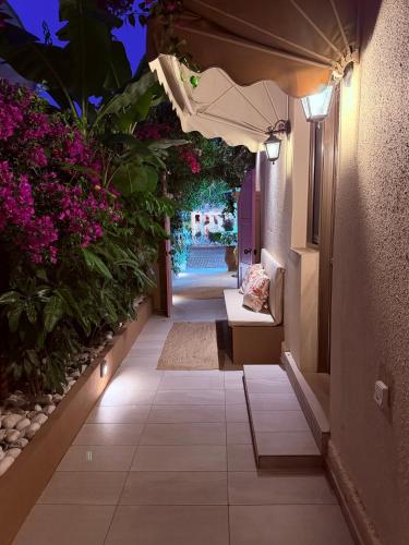 an outdoor pathway with flowers and an umbrella at Carmena Residence in Skala
