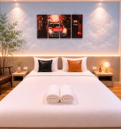 a bedroom with a white bed with two towels at The S Design Hotel in Buriram