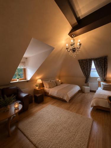 a bedroom with two beds and a couch and a chandelier at Dworek w Karpaczu in Karpacz